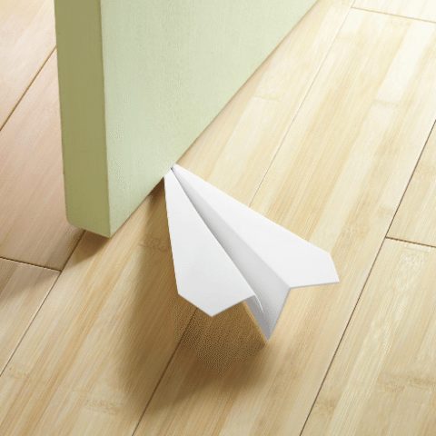 avión de papel como tope de puertas